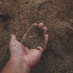 A hand holding some loose soil